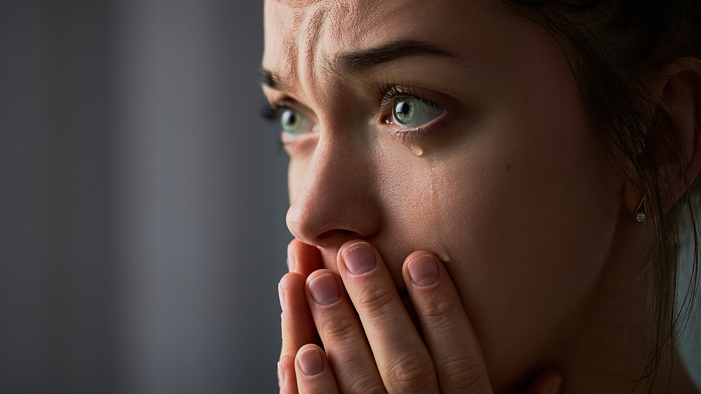 A woman crying, possibly due to the pain and suffering she experienced related to a personal injury claim.