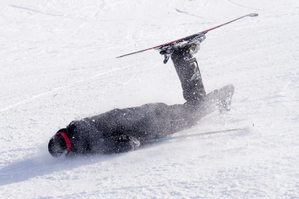 A skiier on the ground after a bad skiing accident.