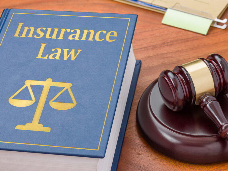 Legal scene with an insurance law book and a gavel on a desk