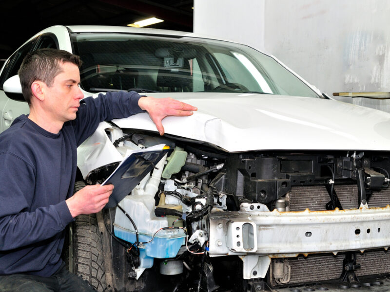 Damaged vehicle getting evaluated by a body shop for repairs. Professional,Car,Appraiser,Evaluate,Car,Damage.